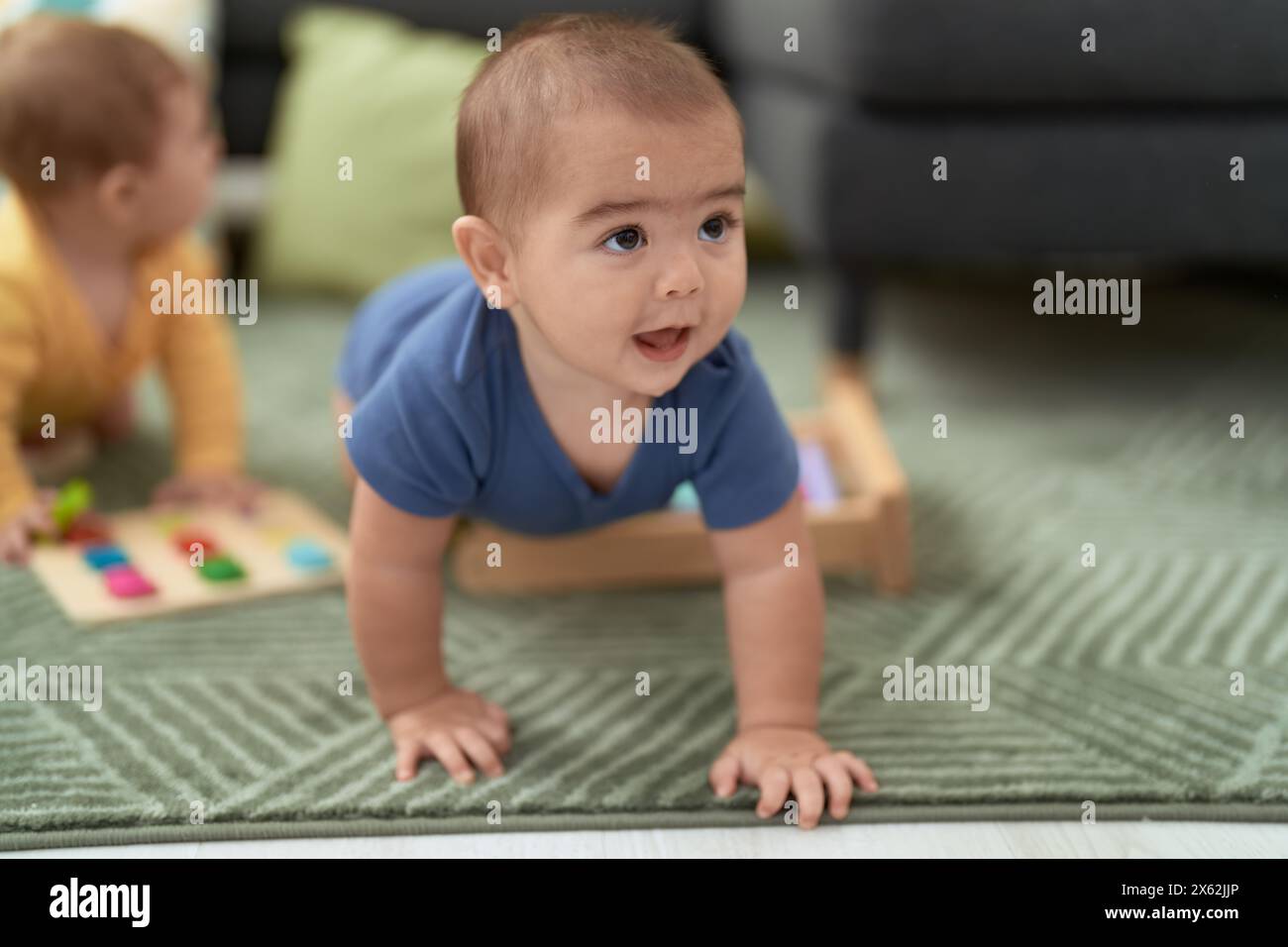 Adorable chinese toddler smiling confident crawling on floor at home Stock Photo