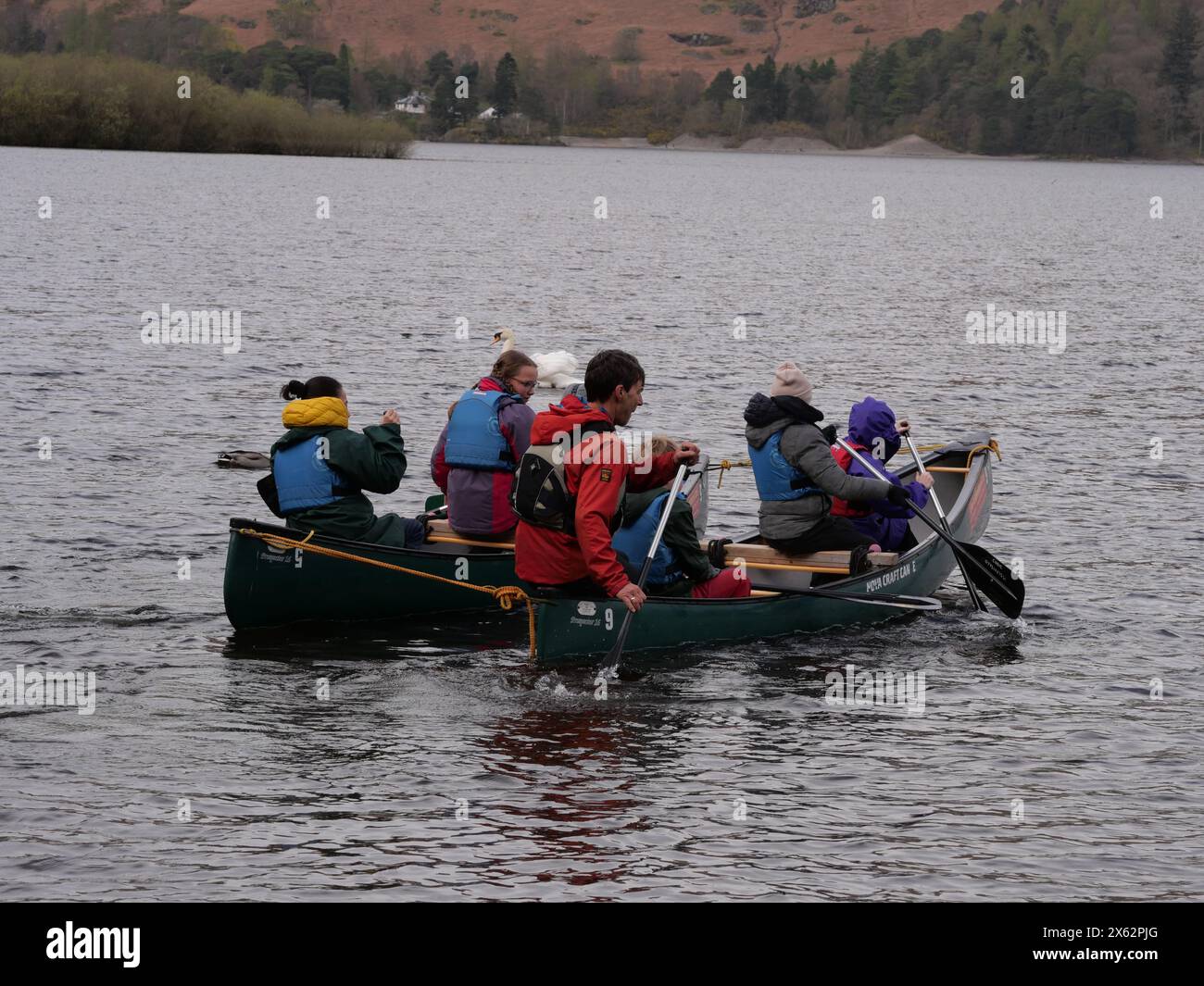 Outdoor pursuits instructor takes a group of children canoeing. Derwentwater, Keswick, Lake District, Cumbria UK Stock Photo