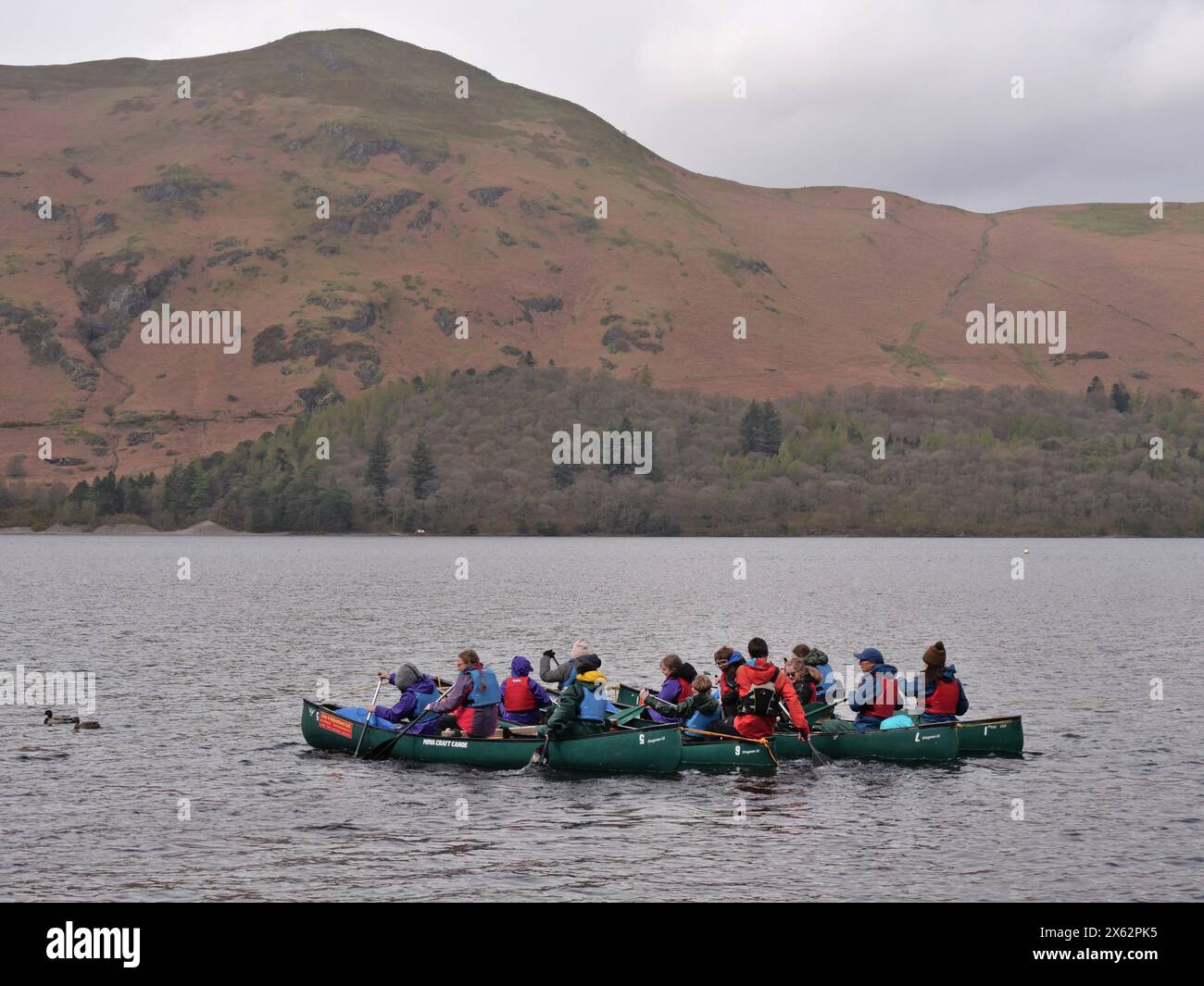 Outdoor pursuits instructor takes a group of children canoeing. Derwentwater, Keswick, Lake District, Cumbria UK Stock Photo