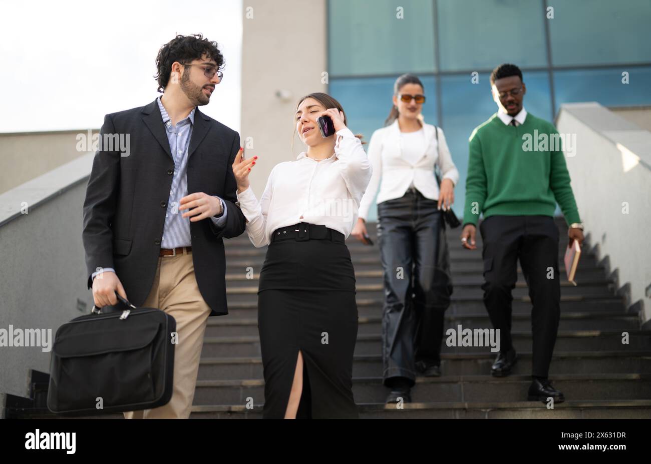 Business professionals walking down the stairs outside the office building Stock Photo