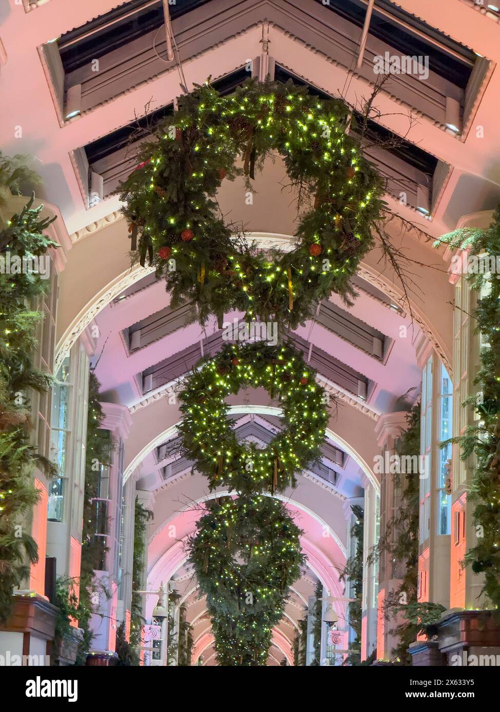 Illuminated Christmas wreaths suspended from the ceiling of the Burlington Arcade in London. Stock Photo