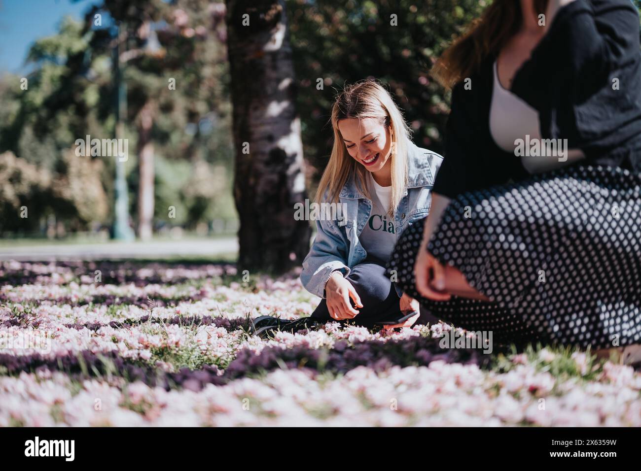 Two young women enjoying a sunshine-filled day at the park amidst ...