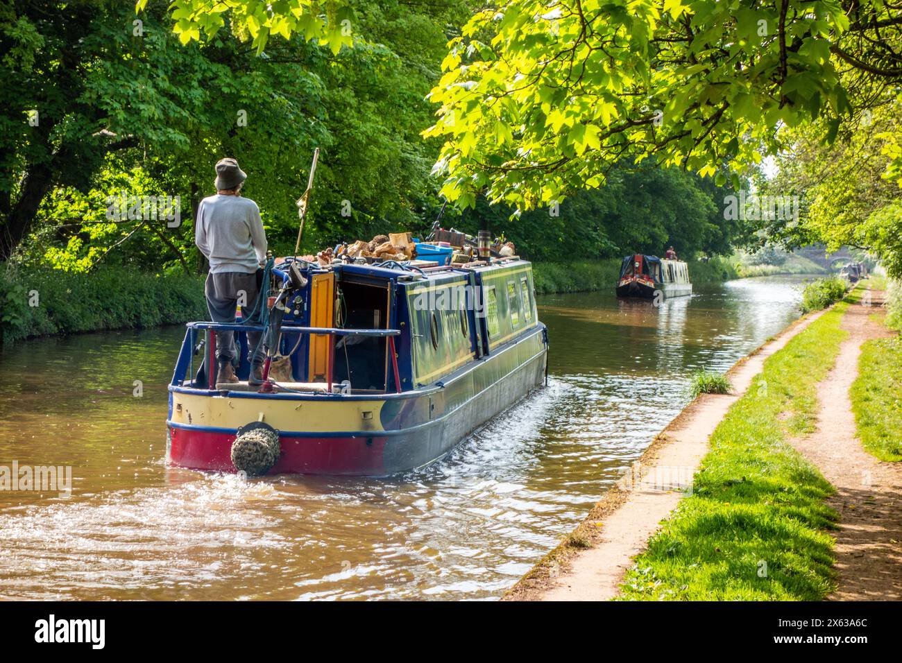 Person  man on canal narrowboat passing through the Shropshire countryside on the Shropshire union canal near the town of Market Drayton England UK Stock Photo