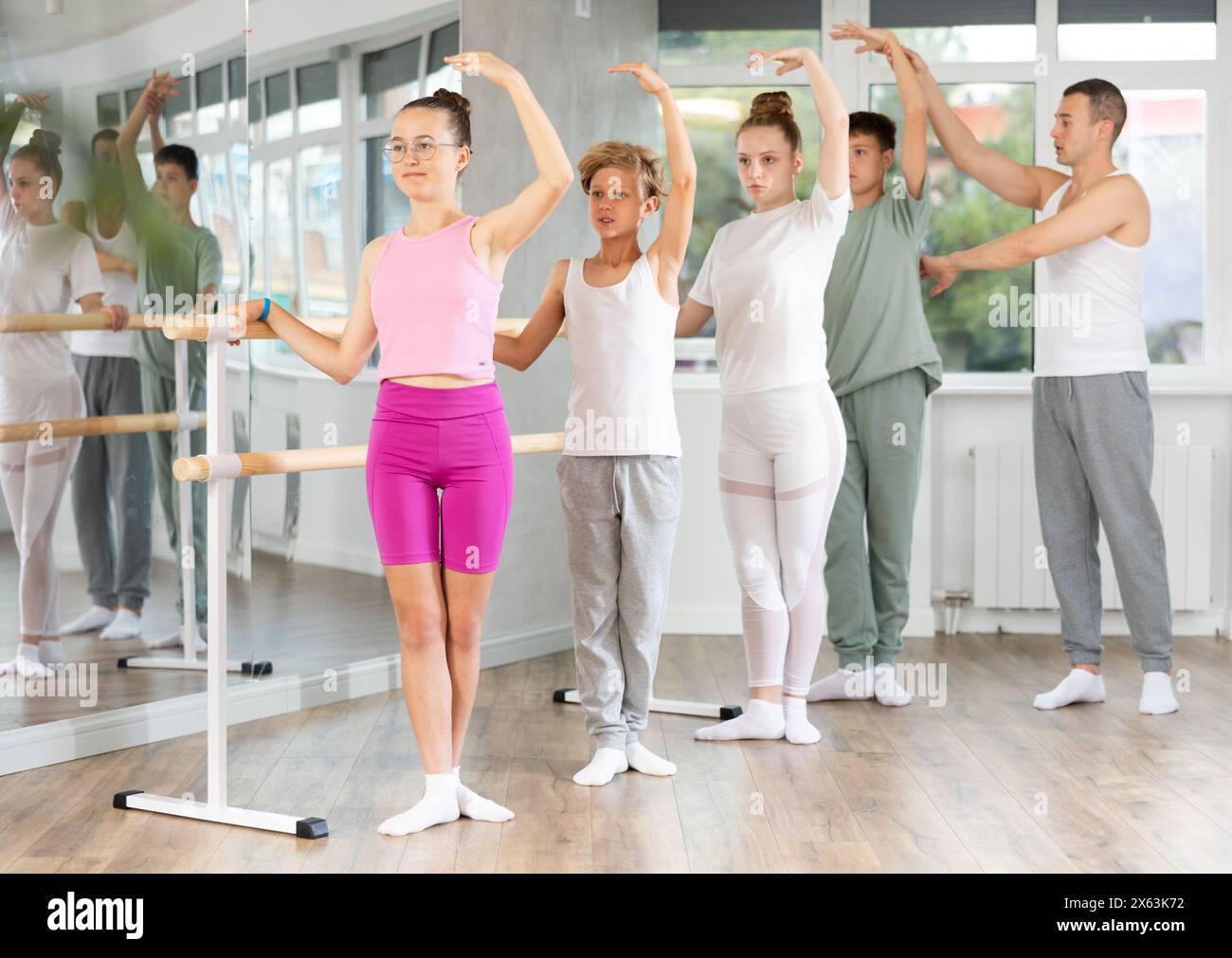 Girls and boys in ballet class perform third position under male ...
