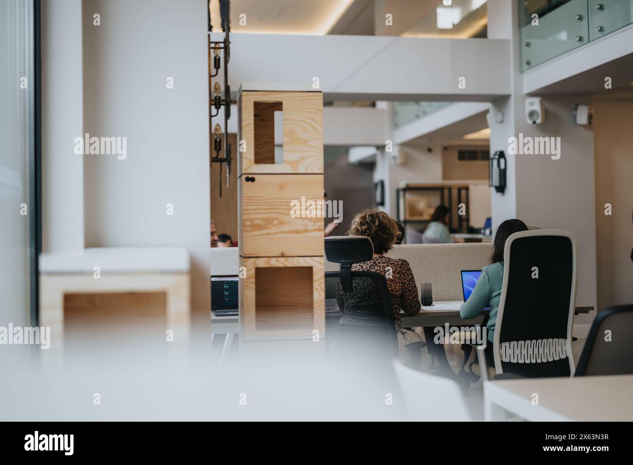 Contemporary office space with employees engaged in work at desks Stock ...