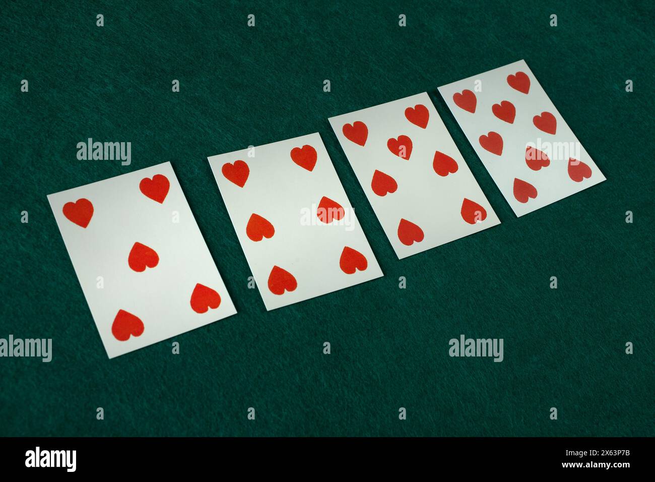 Old west era playing card on on green gambling table. 5, 6, 7, 8 of hearts. Stock Photo