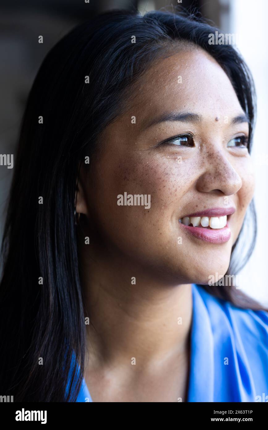 At office, biracial businesswoman with freckles looking away Stock Photo