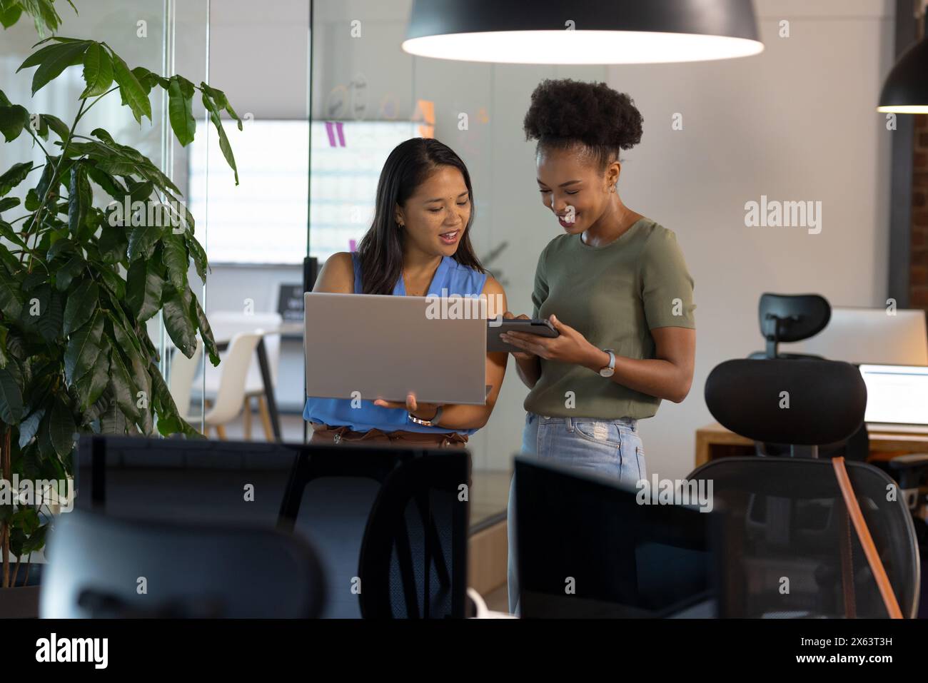 At office, diverse female business colleagues discussing work Stock Photo