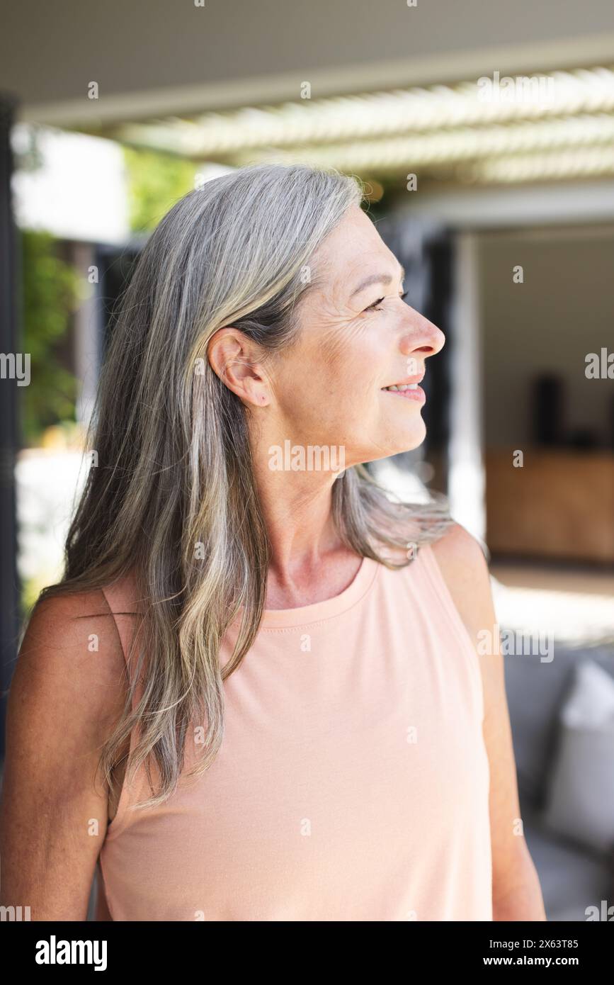 At home, Caucasian mature woman looking away, standing outdoors Stock Photo