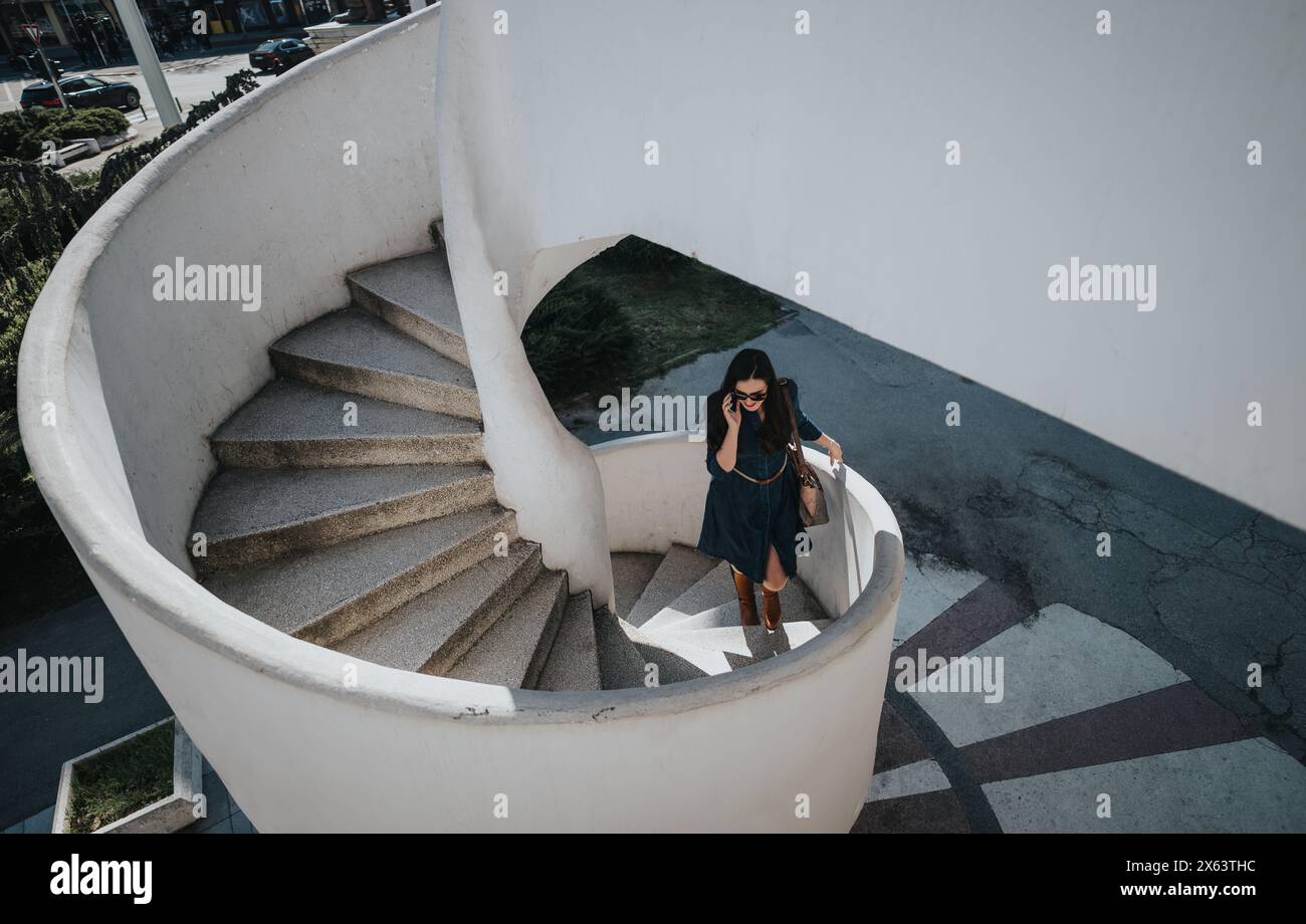 Professional woman on a phone call descending outdoor staircase Stock Photo