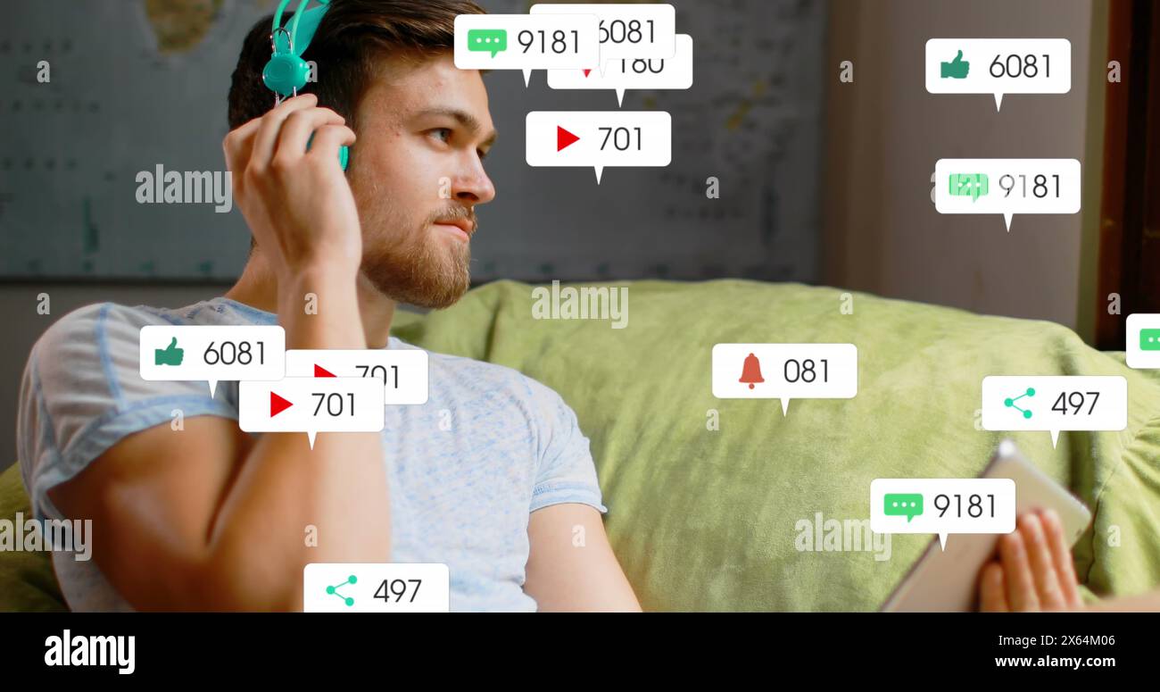 Image of social media icons over caucasian man listening to music using a tablet at home Stock Photo