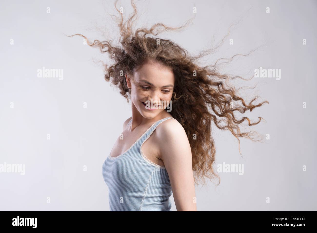 Portrait of a gorgeous teenage girl with flying curly hair, blowing in ...