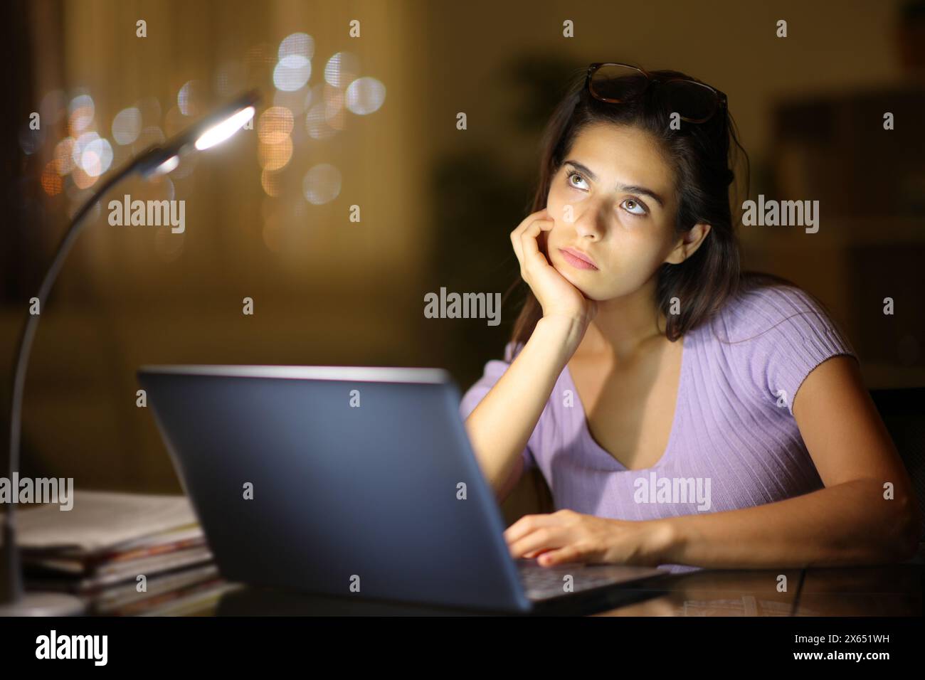 Pensive serious woman at home with a laptop in the night Stock Photo