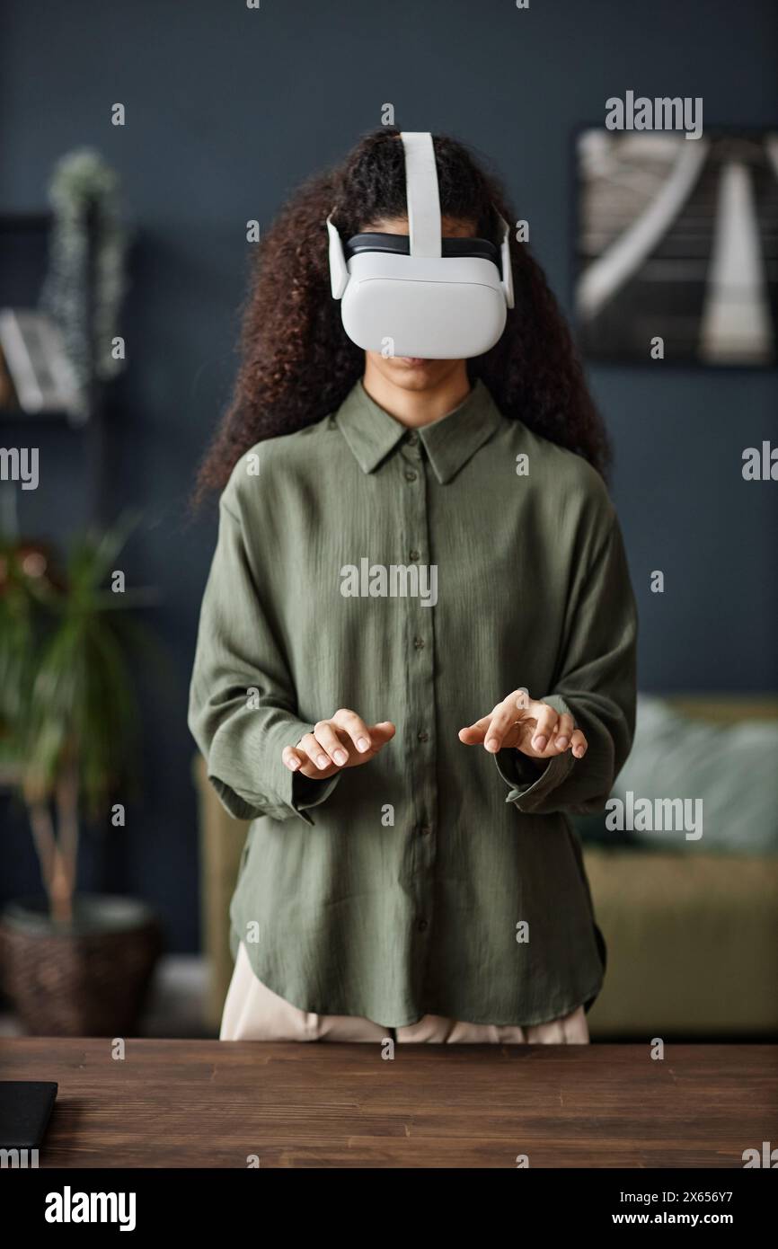 Vertical medium shot of biracial girl with curly hair wearing vr
