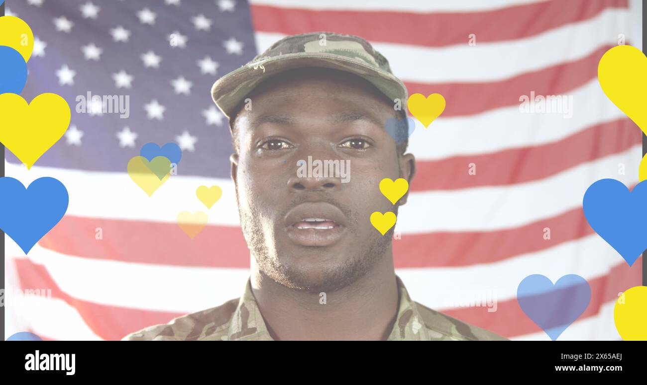 Image of yellow and blue hearts over african american male soldier singing anthem on usa flag. Ukraine crisis and international politics concept digit Stock Photo