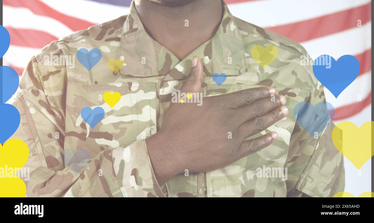 Image of yellow and blue hearts over african american male soldier singing anthem on usa flag. Ukraine crisis and international politics concept digit Stock Photo
