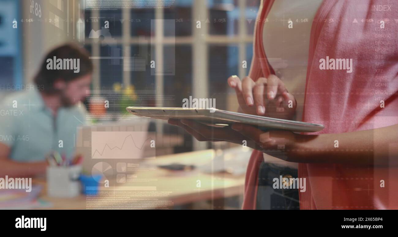 Diverse couple holding tablet, working together Stock Photo