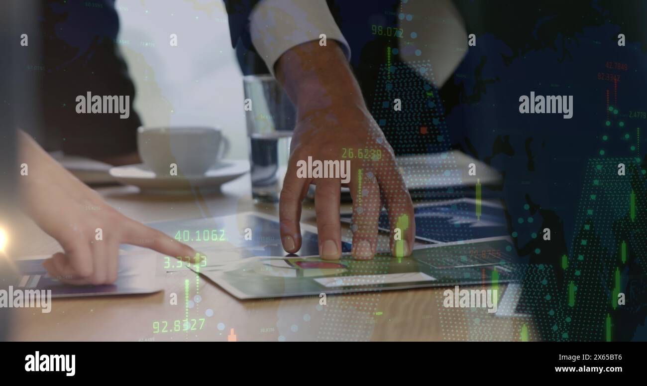 Two people wearing business attire are examining documents on table Stock Photo