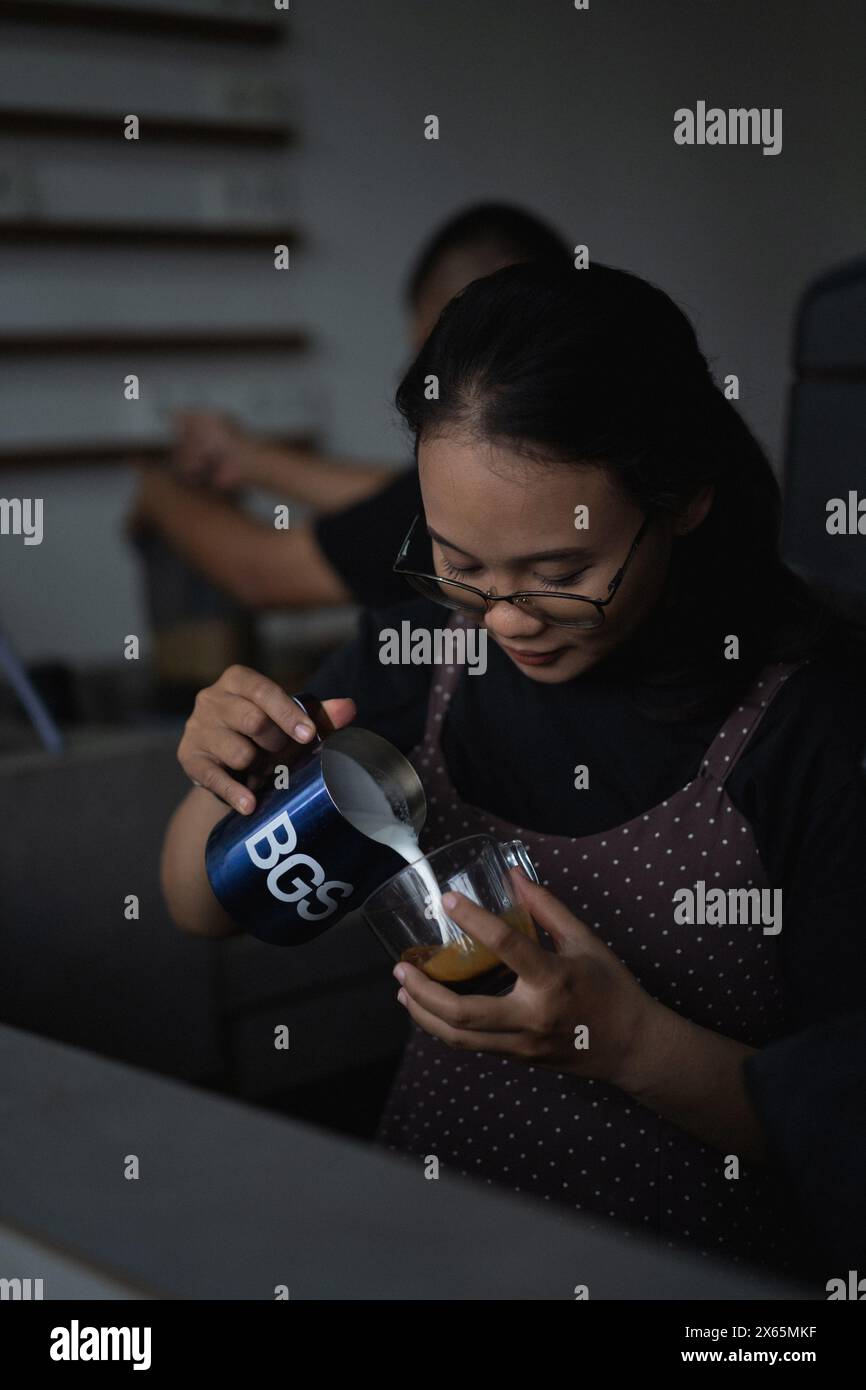 Young baristo woman making coffee in a cafe. Bali Stock Photo