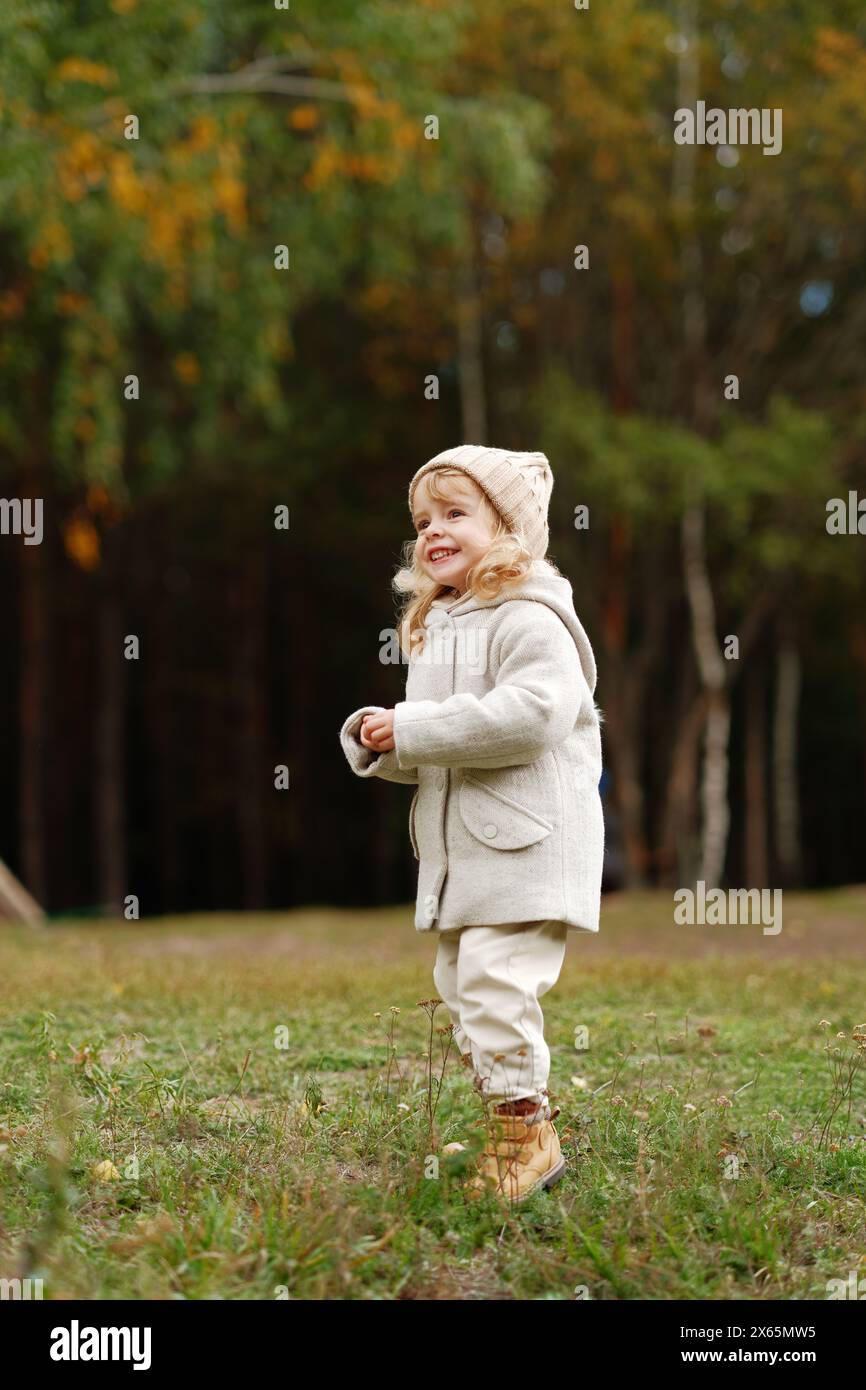 happy little girl walks through the autumn forest and plays Stock Photo