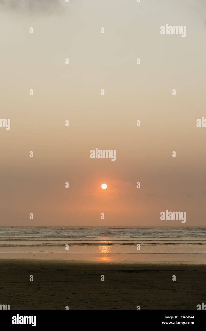 Sun setting over ocean horizon Stock Photo