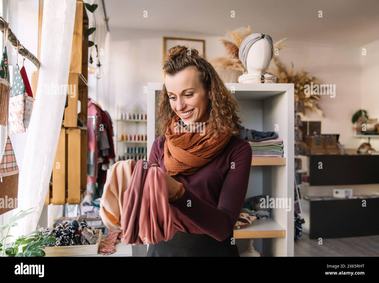 Woman Happily Exploring Fabric Choices in a Boutique Craft Shop Stock Photo