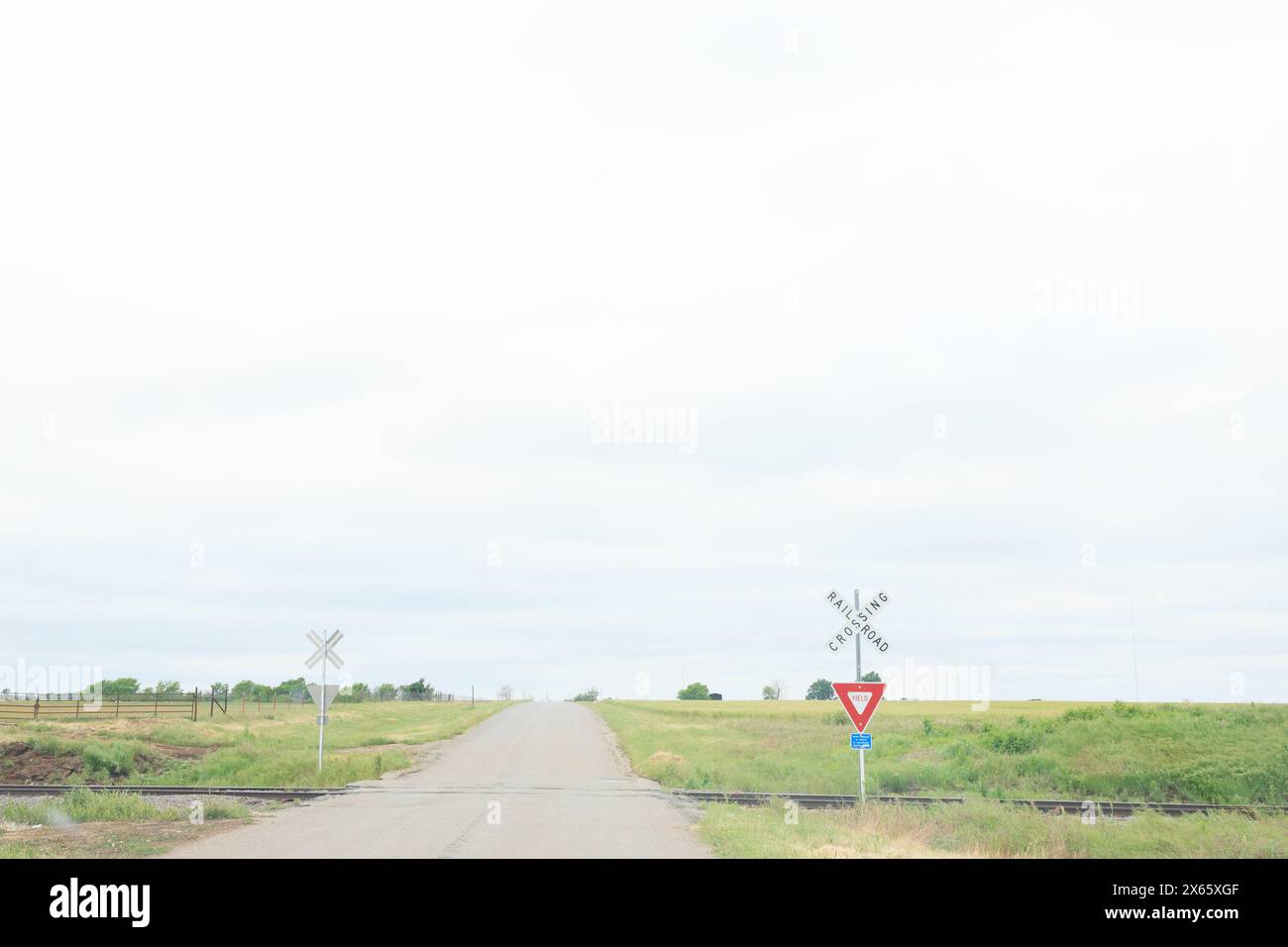 A quiet rural road with a railroad crossing. Stock Photo