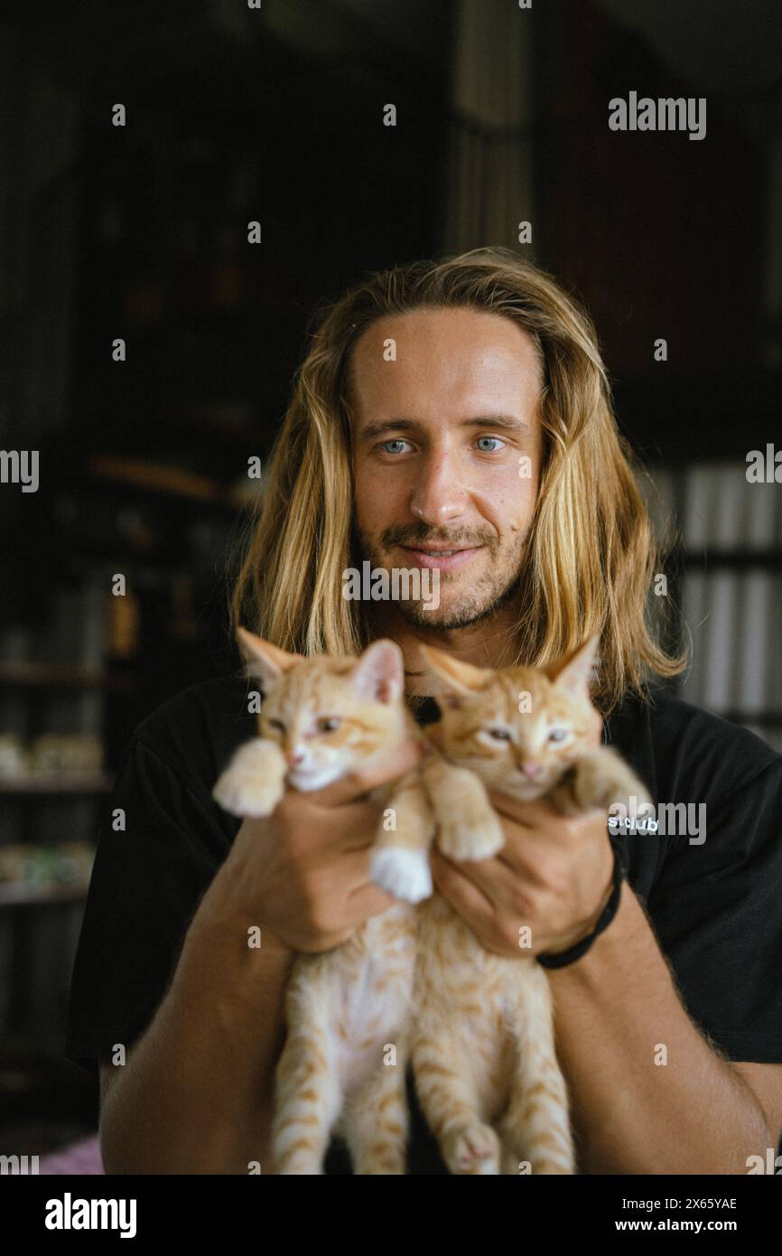 Young man holds red kittens. Stock Photo