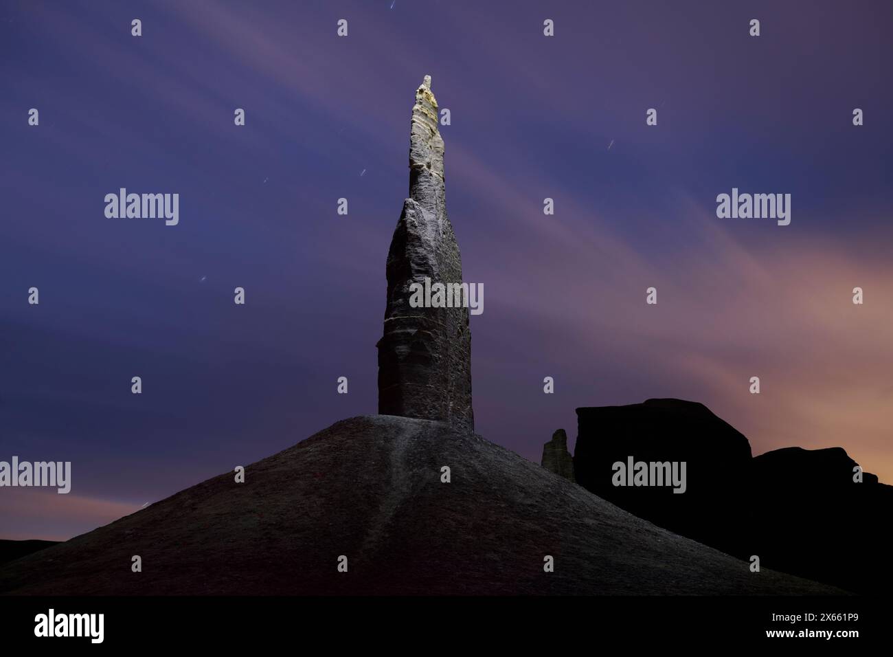 A lone spire illuminated at night during a bright moonrise. Stock Photo