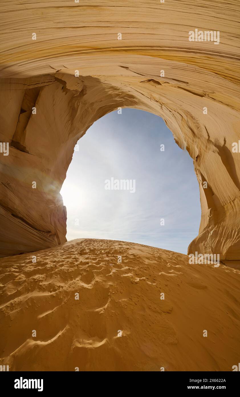 A sand dune and massive alcove carved into a cliff in the Utah d Stock Photo