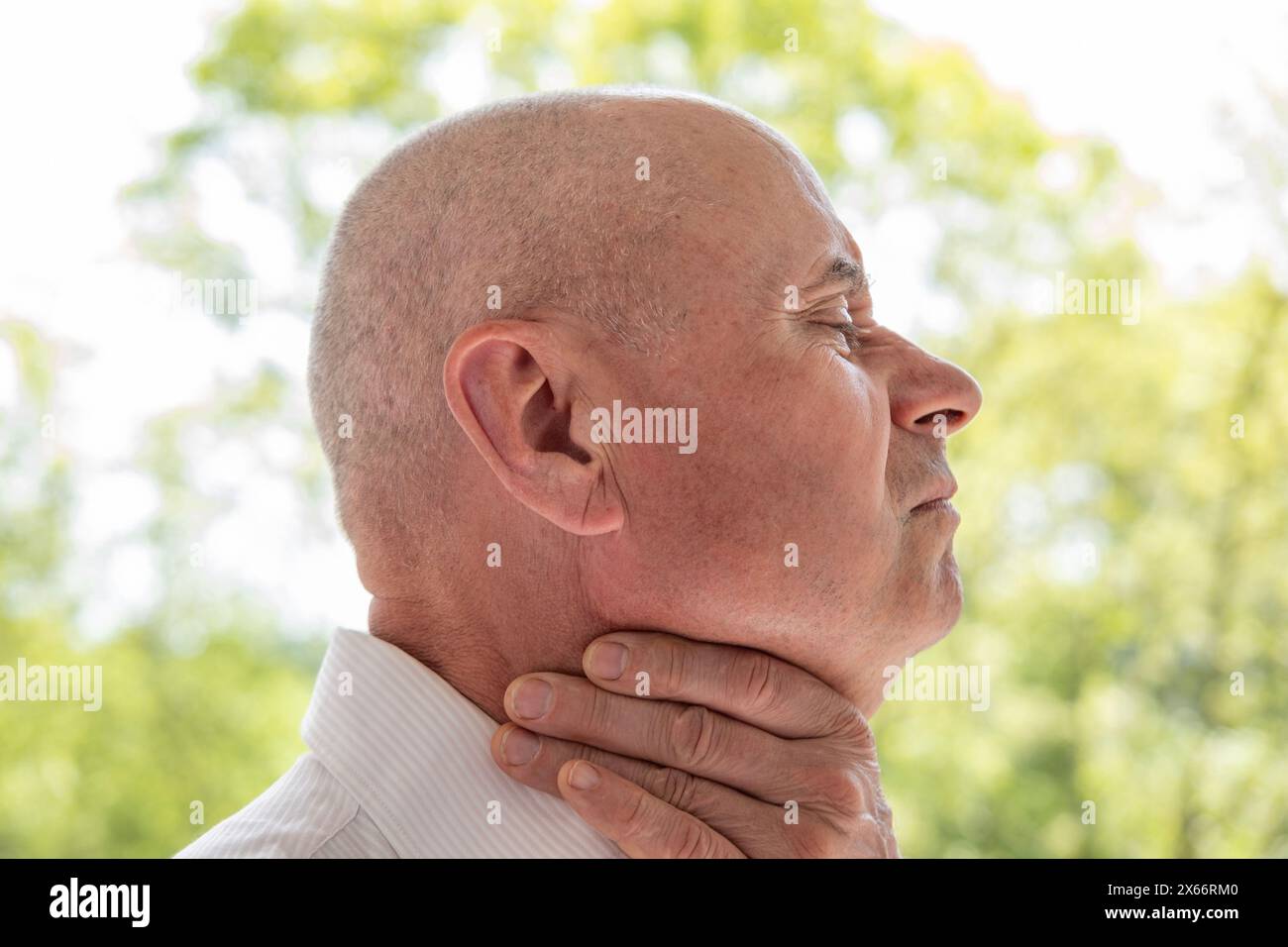 Elderly man 60-65 years, old patient holding affected area, experiencing throat pain, Health concern, loss of voice, various causes, medical attention Stock Photo