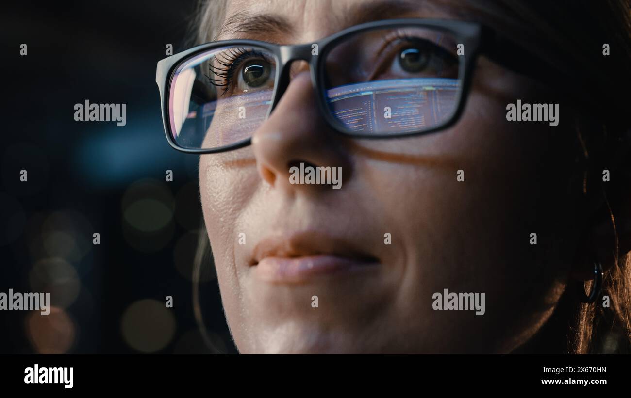 Close-up Portrait of Female Software Engineer Working on Computer, Programming Reflecting in Glasses. Developer Working on Innovative e-Commerce Application using Machine Learning, AI, Big Data Stock Photo