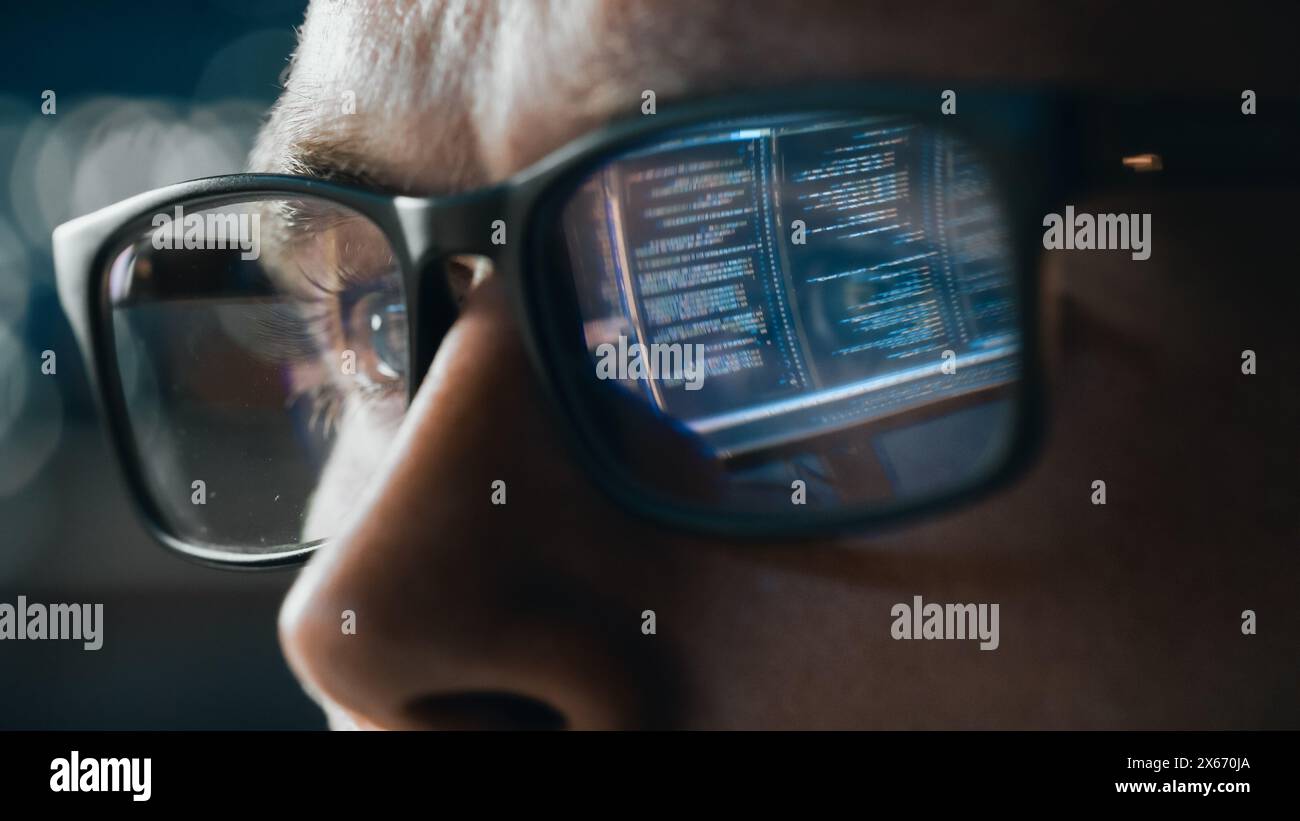 Close-up Portrait of Software Engineer Working on Computer, Line of Code Reflecting in Glasses. Developer Working on Innovative e-Commerce Application using Big Data Concept Stock Photo