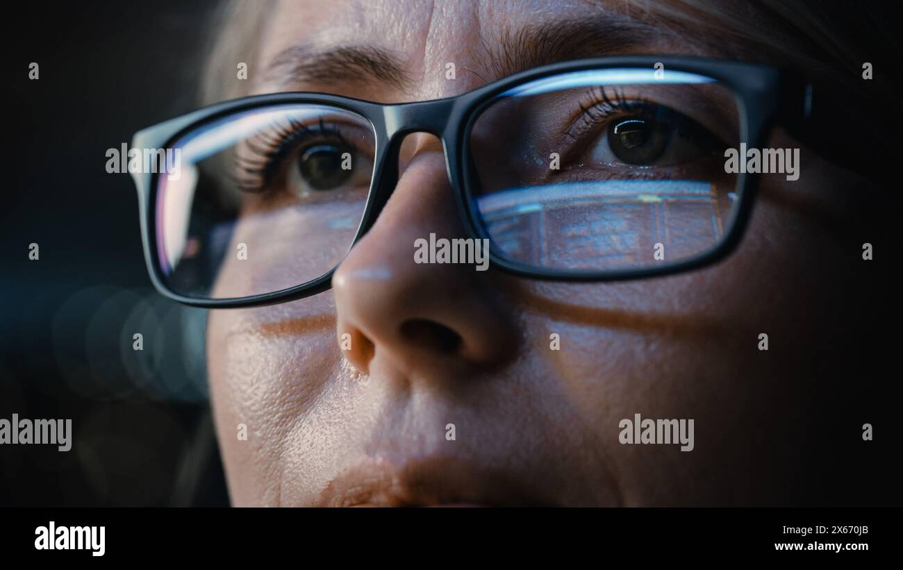 Close-up Portrait of Female Software Engineer Working on Computer, Programming Reflecting in Glasses. Developer Working on Innovative e-Commerce Application using Machine Learning, AI, Big Data Stock Photo