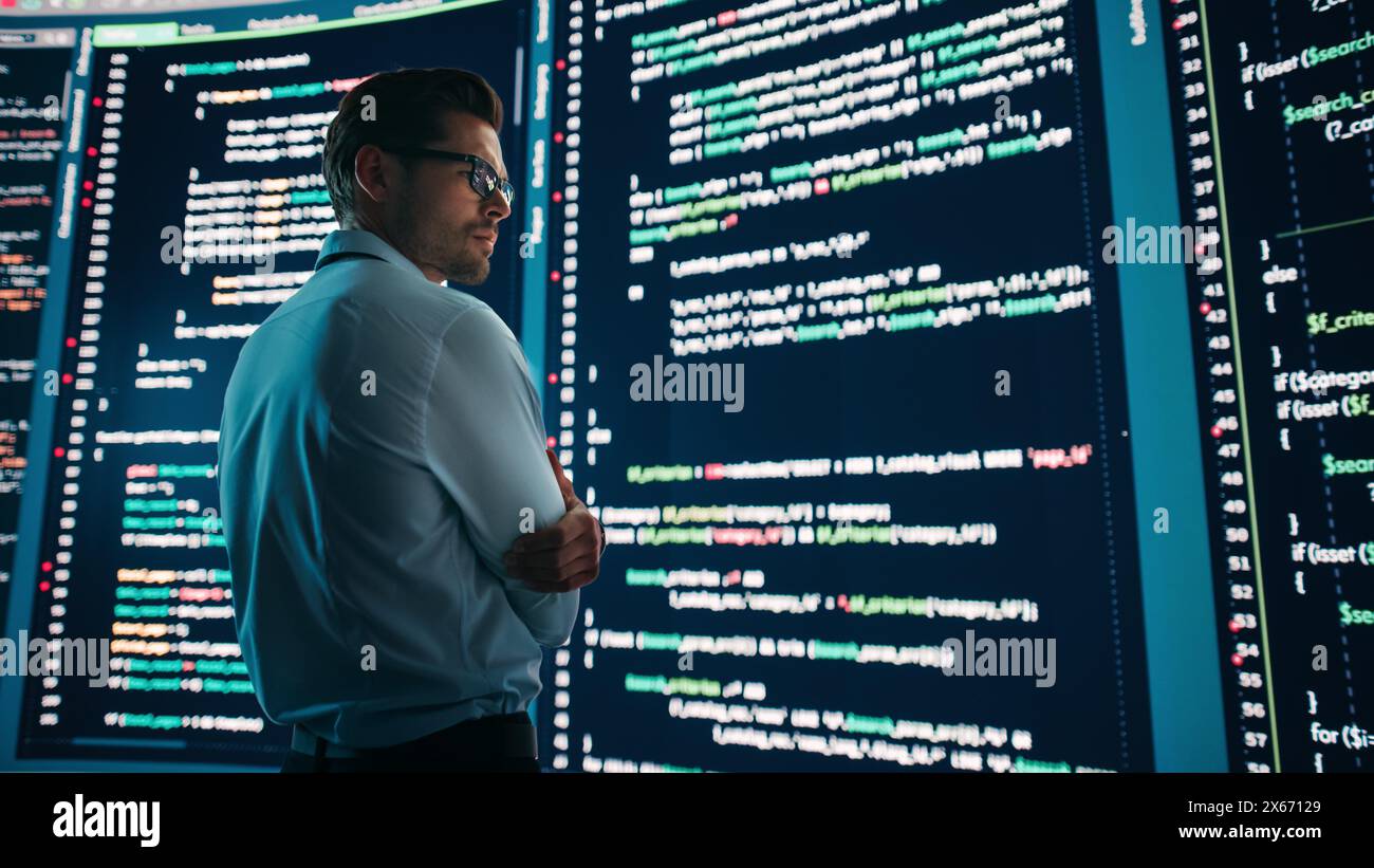 Innovative Startup Concept: Thoughtful Software Engineer Finding Solution, Planning Strategy, Standing and Doing Data Analysis on Big Wall Screen. Programmer Developing e-Commerce App. Stock Photo