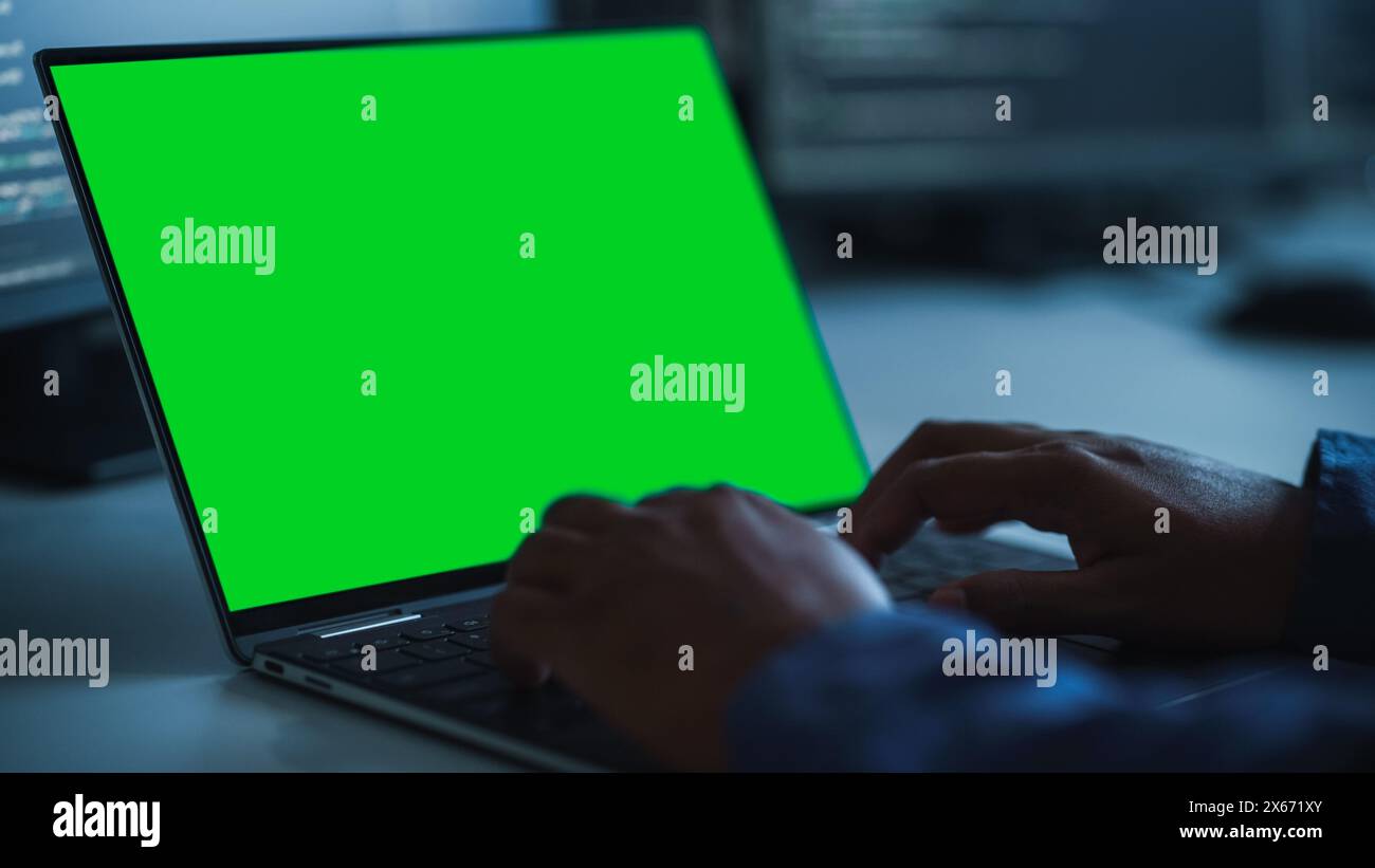 Close-up Focus on Person's Hands Typing on the Green Screen Chroma key Laptop Computer Keyboard. Software Engineer Create Innovative e-Commerce App. Program Development Stock Photo