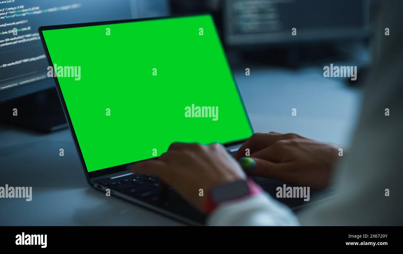 Close-up Focus on Person's Hands Typing on the Green Screen Chroma key Laptop Computer Keyboard. Software Engineer Create Innovative e-Commerce App. Program Development Stock Photo