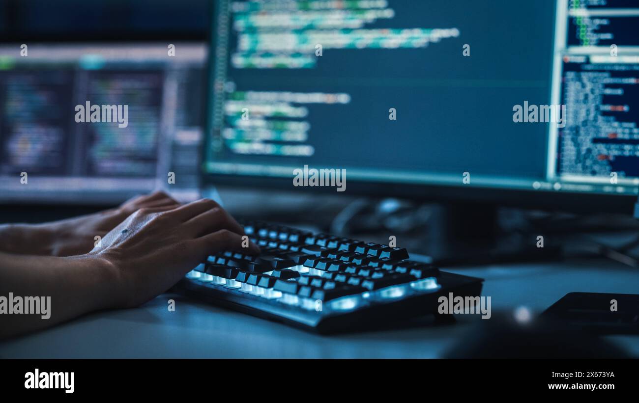 Close-up Focus on Person's Hands Typing on the Desktop Computer Backlit Keyboard. Screens Show Coding Language User Interface. Software Engineer Create Innovative e-Commerce App. Program Development Stock Photo