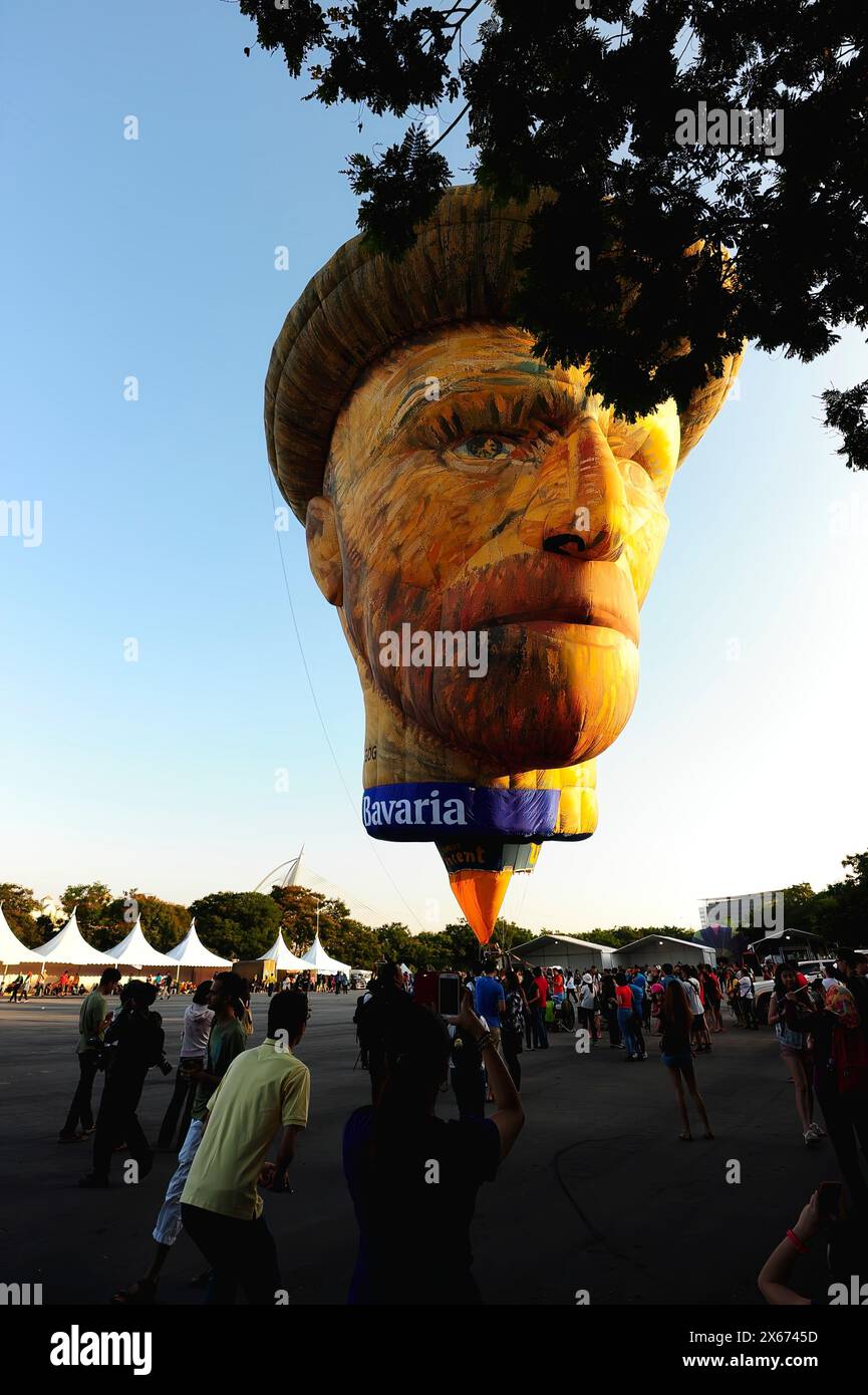 A large balloon shaped like a man's face is being flown in the air. The ...