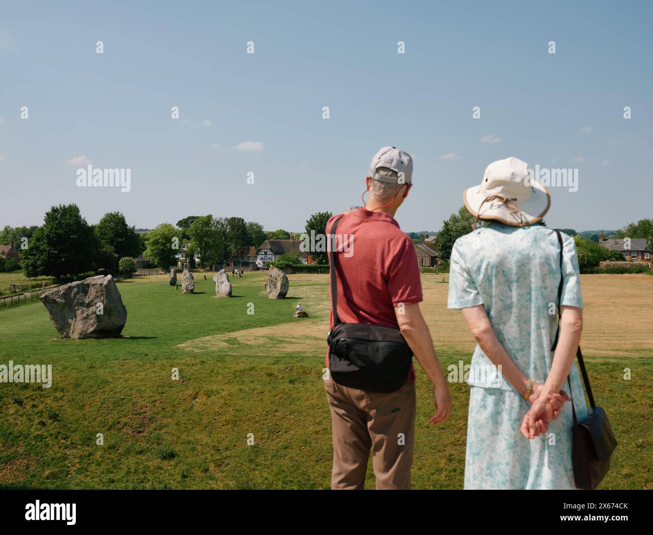 Tourist couple at the South Inner Circle of Avebury Neolithic henge in Avebury, Wiltshire, England UK - megalithic stone circle tourists tourism Stock Photo