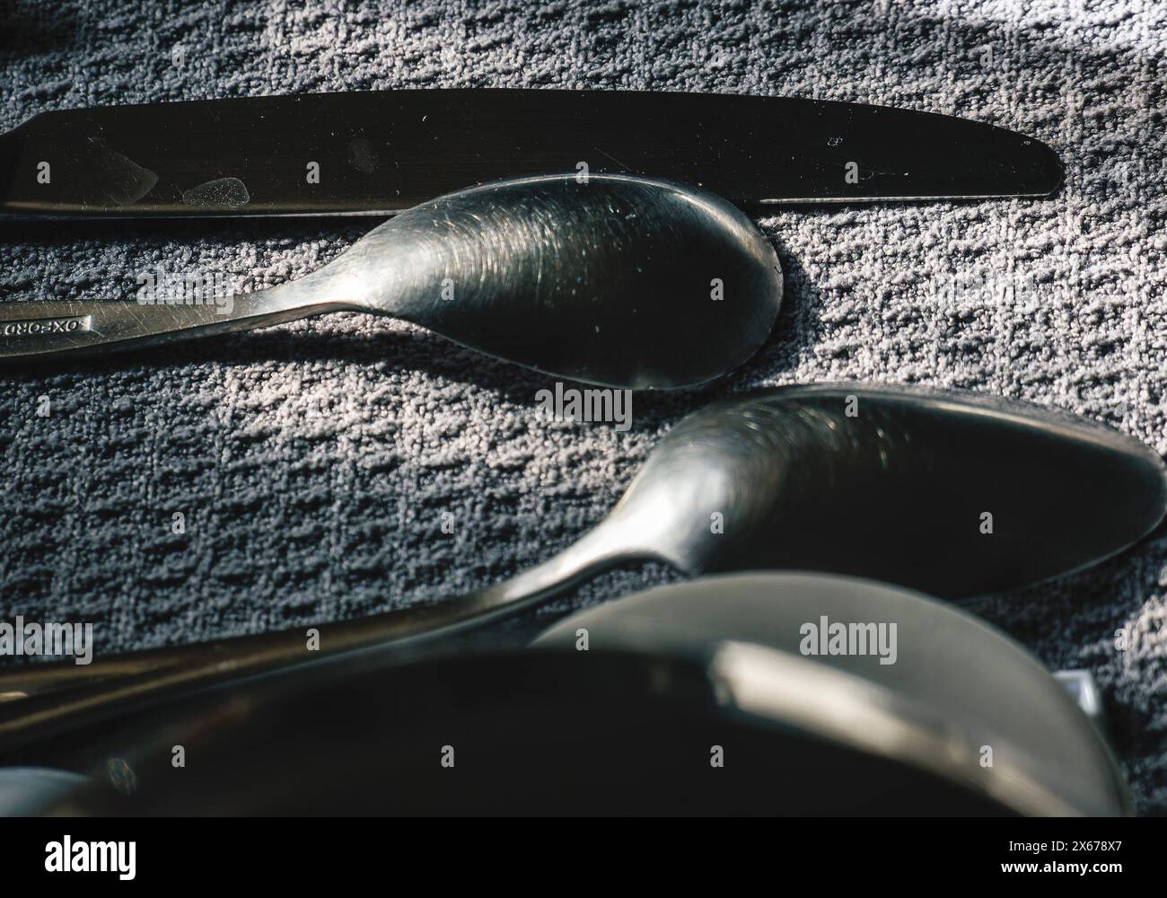 Spoons on a cloth drying by the kitchen sink Stock Photo