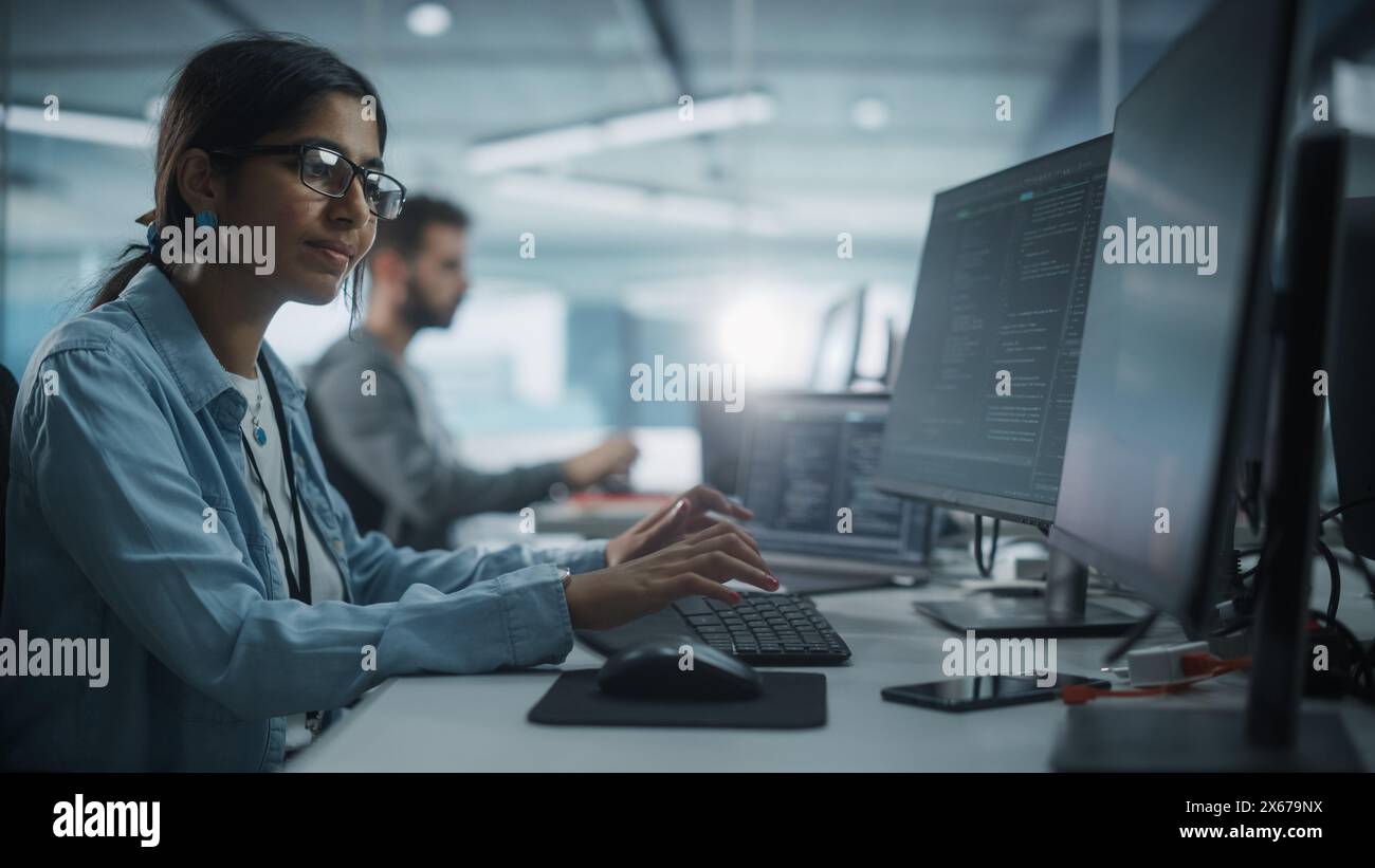 Diverse Office: Indian IT Programmer Working on Desktop Computer. Female Specialist Creating Innovative Software. Engineer Developing App, Program, Video Game. Writing Code in Terminal. Stock Photo