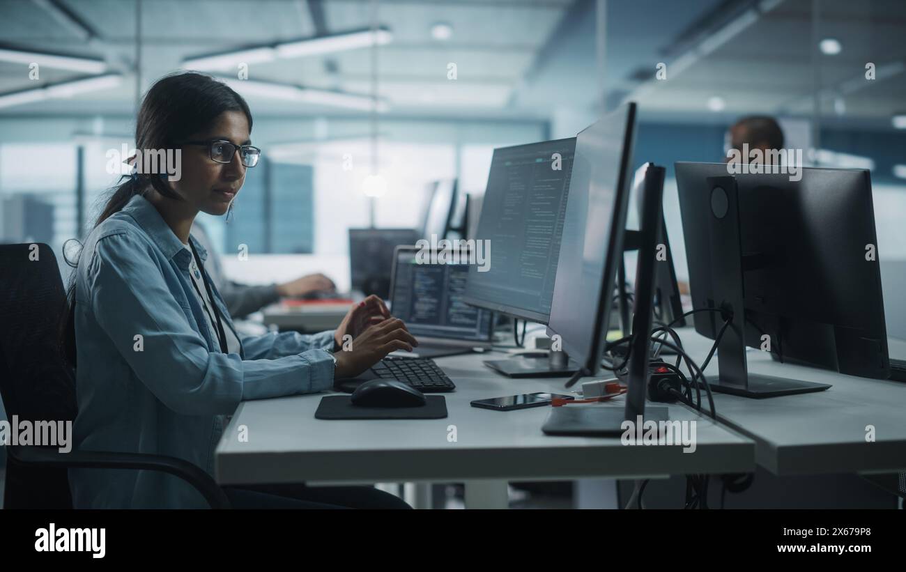 Diverse Office: Indian IT Programmer Working on Desktop Computer. Female Specialist Creating Innovative Software Engineer Developing App, Program, Video Game. Terminal with Coding Language. Stock Photo