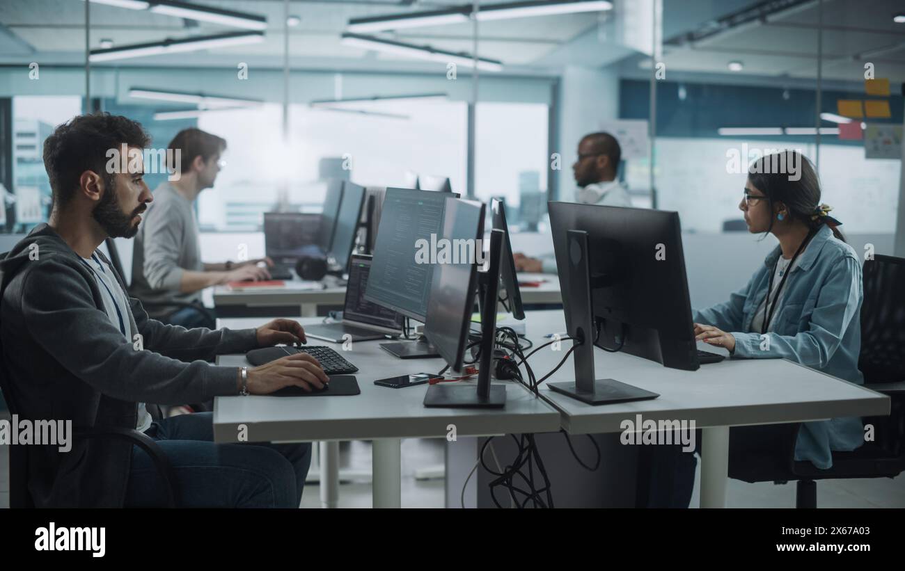 Diverse Multi-Ethnic Team Working in Big City Office: IT Programmers Working on Desktop Computers. Specialists Creating Innovative Software. Engineers Developing Inspiration App, Program. Stock Photo