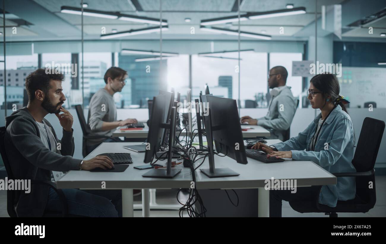 Diverse Multi-Ethnic Team Working in Big City Office: IT Programmers Working on Desktop Computers. Specialists Creating Innovative Software. Engineers Developing Inspiration App, Program. Stock Photo
