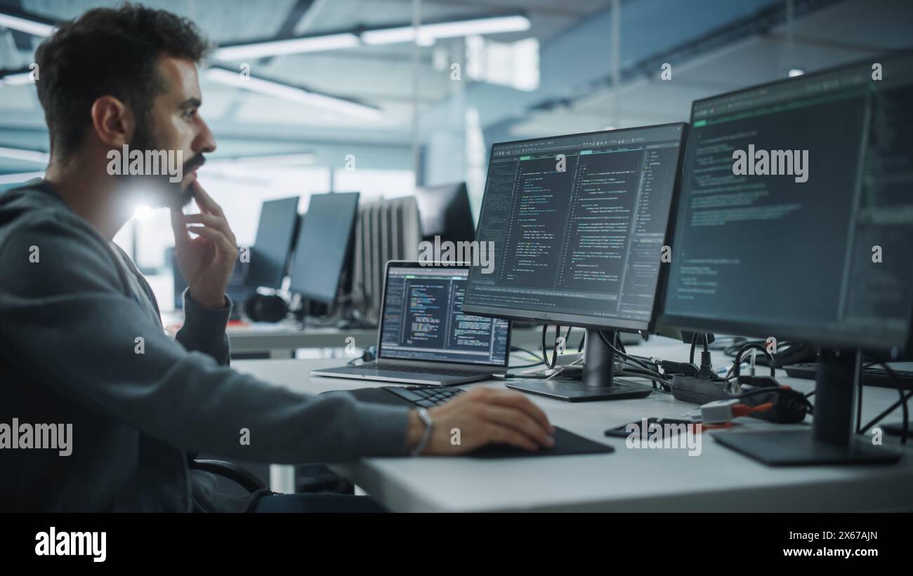 Diverse Office: Enthusiastic White IT Programmer Working on Desktop Computer. Male Specialist Creating Innovative Software. Engineer Developing App, Program, Video Game. Writing Code in Terminal Stock Photo