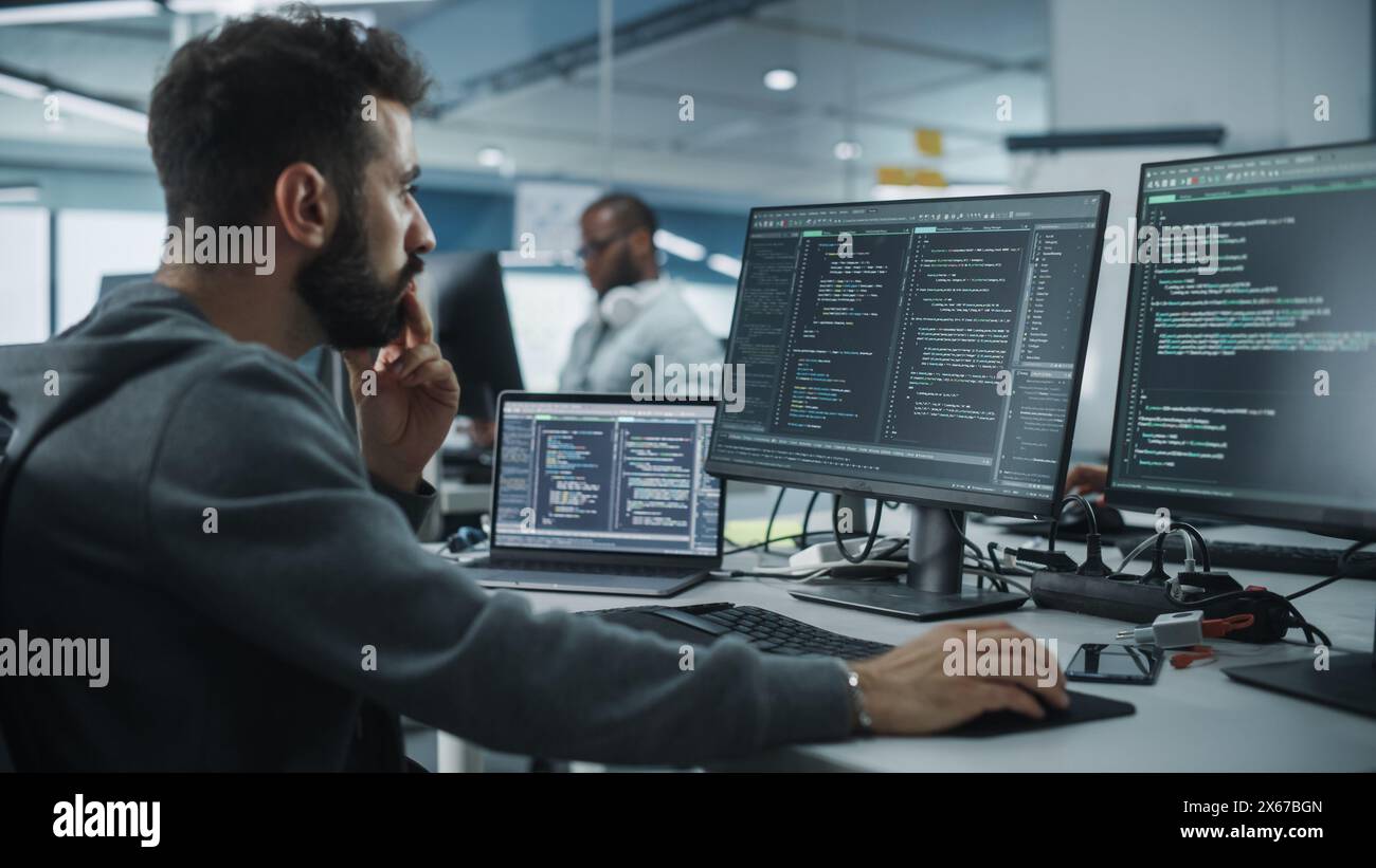 Diverse Office: Enthusiastic White IT Programmer Working on Desktop Computer. Male Specialist Creating Innovative Software. Engineer Developing App, Program, Video Game. Writing Code in Terminal Stock Photo