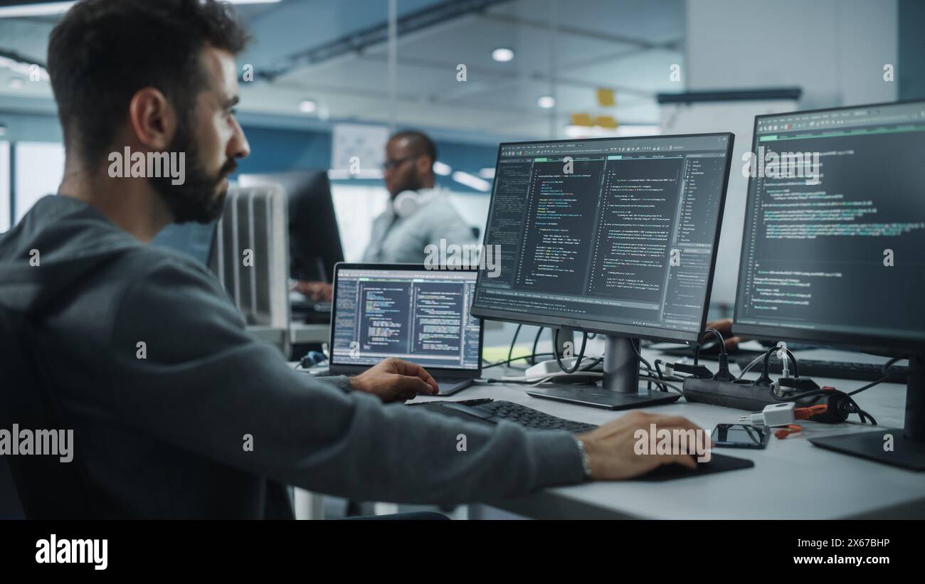 Diverse Office: Enthusiastic White IT Programmer Working on Desktop Computer. Male Specialist Creating Innovative Software. Engineer Developing App, Program, Video Game. Writing Code in Terminal Stock Photo
