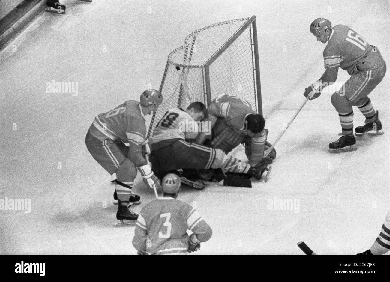 Vintage Winter Olympics Games Photo: Grenoble 68, Ice hockey competition.   USSR v Sweden 3-2.  Soviet Goalie, Victor Zinger,  stops puck in crease, during match action. Stock Photo