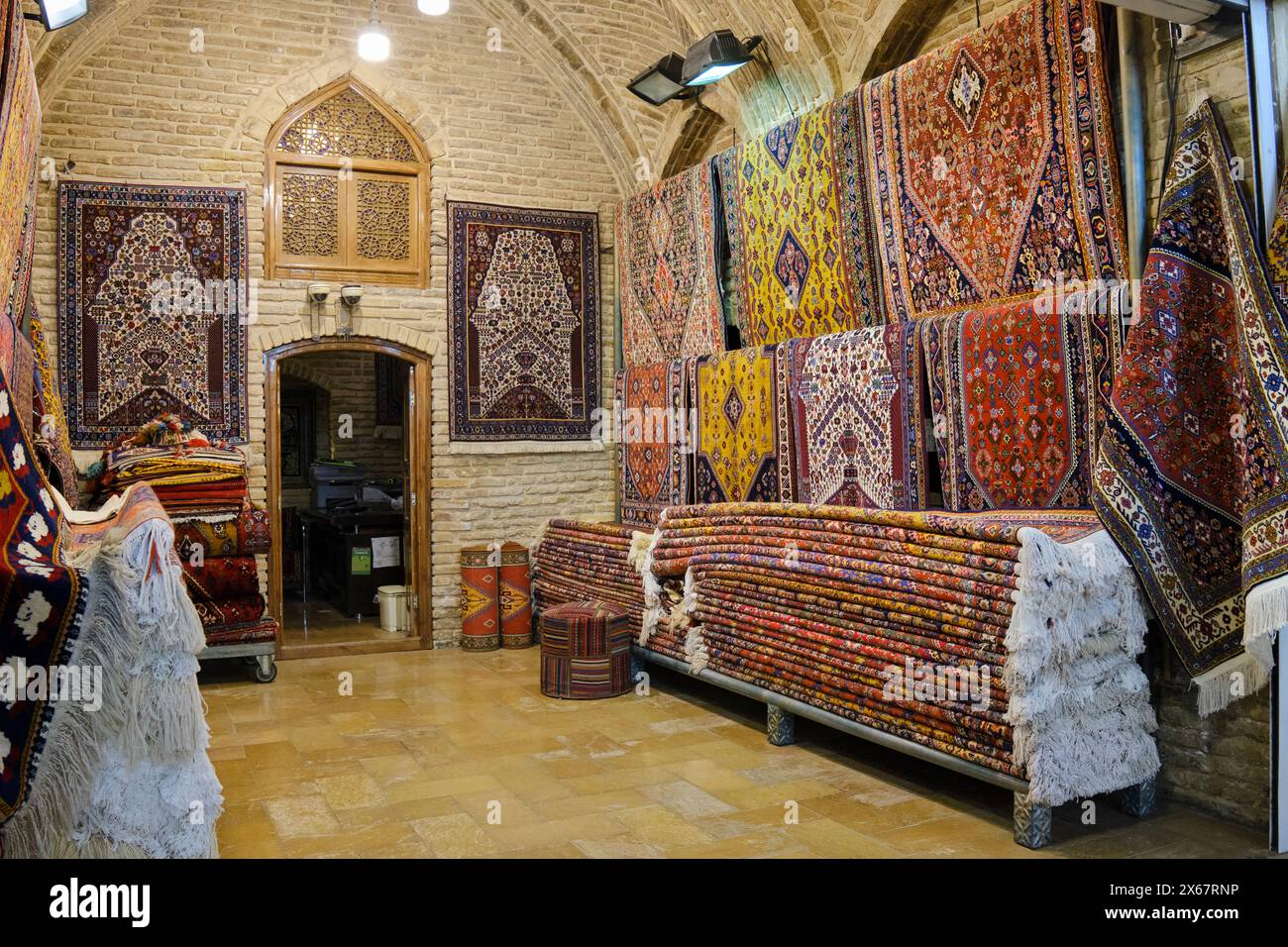 A selection of handmade Persian carpets displayed inside a carpet store at Vakil Bazaar. Shiraz, Iran. Stock Photo